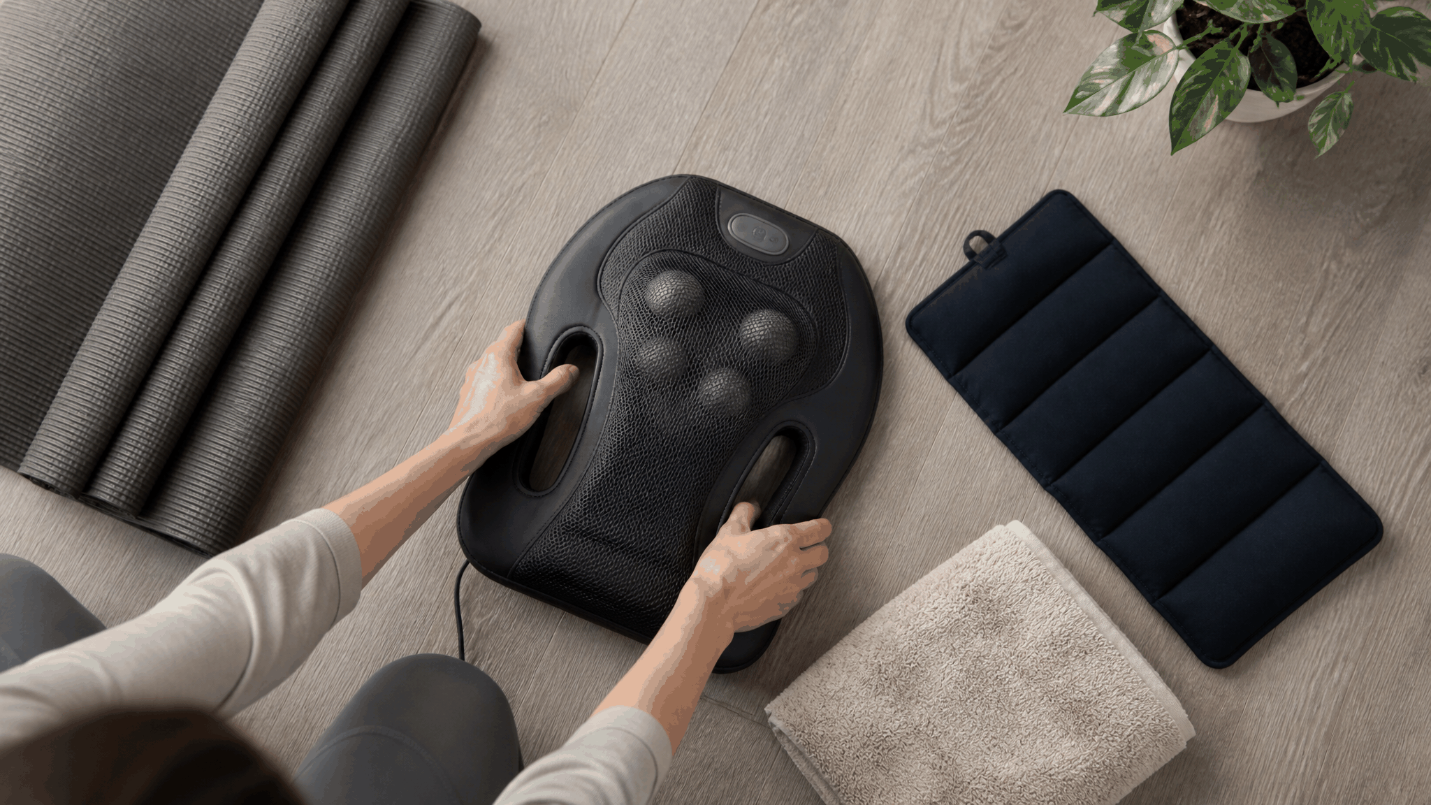 Back massager with black textured casing and rounded massage nodes, shown with accessories to Ease Lower Back Pain

