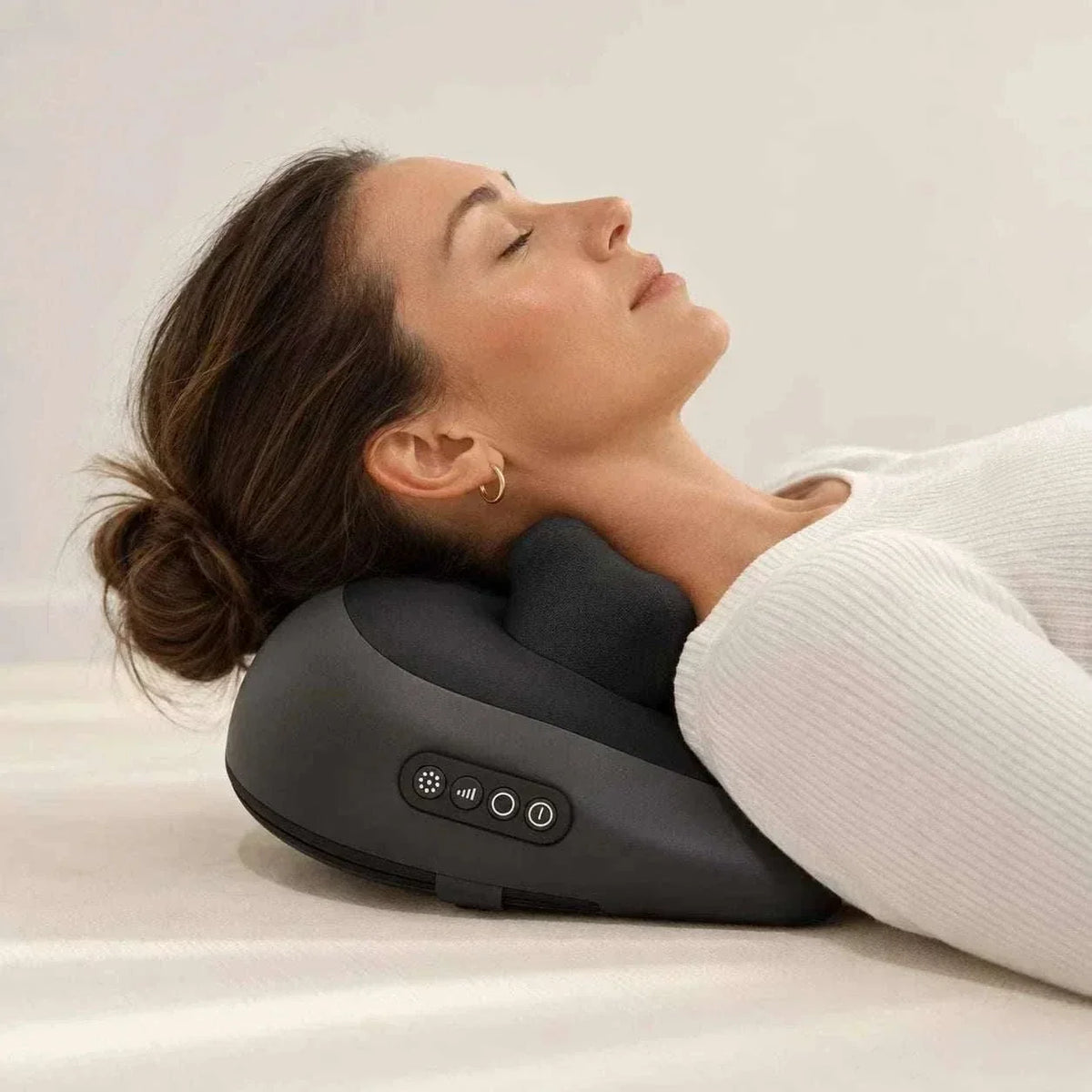 Cordless shiatsu neck massager in black plastic with raised padded kneading sections and simple side control buttons