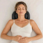 Cordless shiatsu neck massager in black plastic with padded kneading nodes and side control buttons, worn around the neck