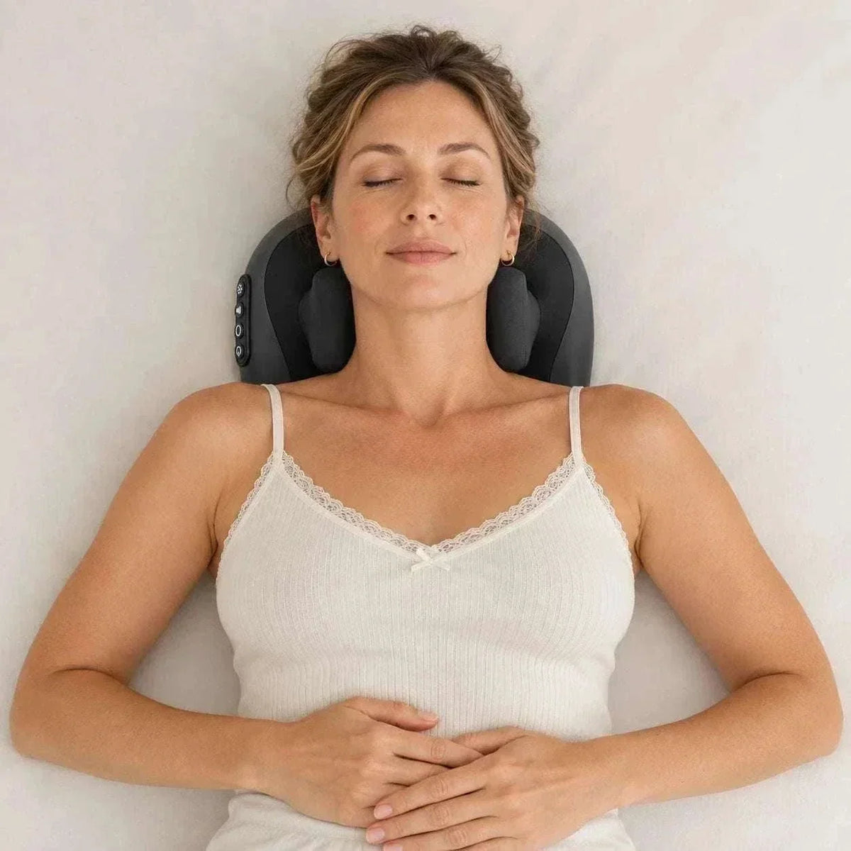 Cordless shiatsu neck massager in black plastic with padded kneading nodes and side control buttons, worn around the neck